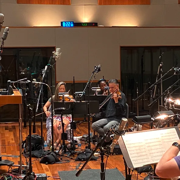 Musicians playing string instruments during a recording workshop